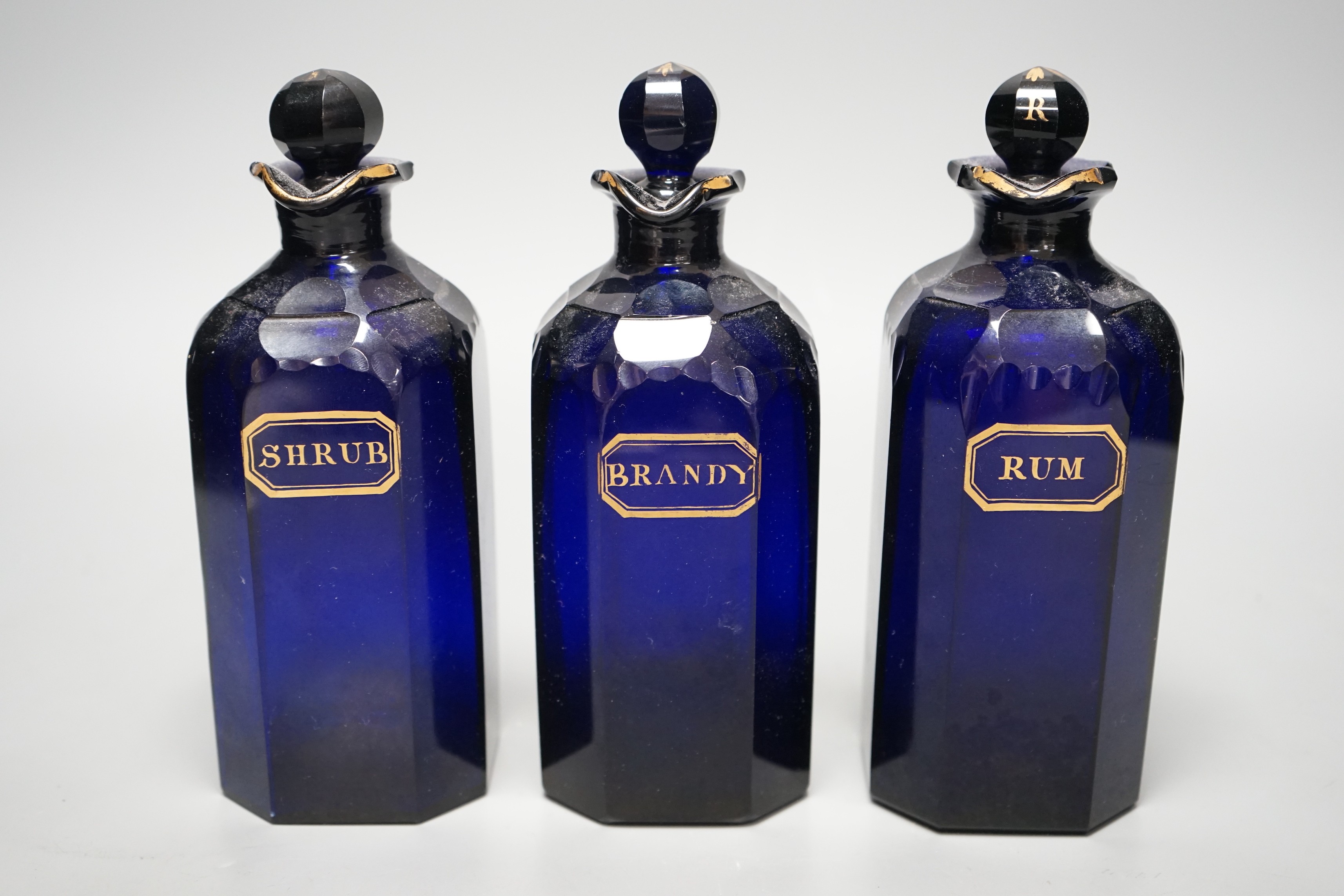 Three Georgian Bristol Blue gilt labelled decanters, ‘rum’, ‘brandy’ and ‘shrub’ 20cm